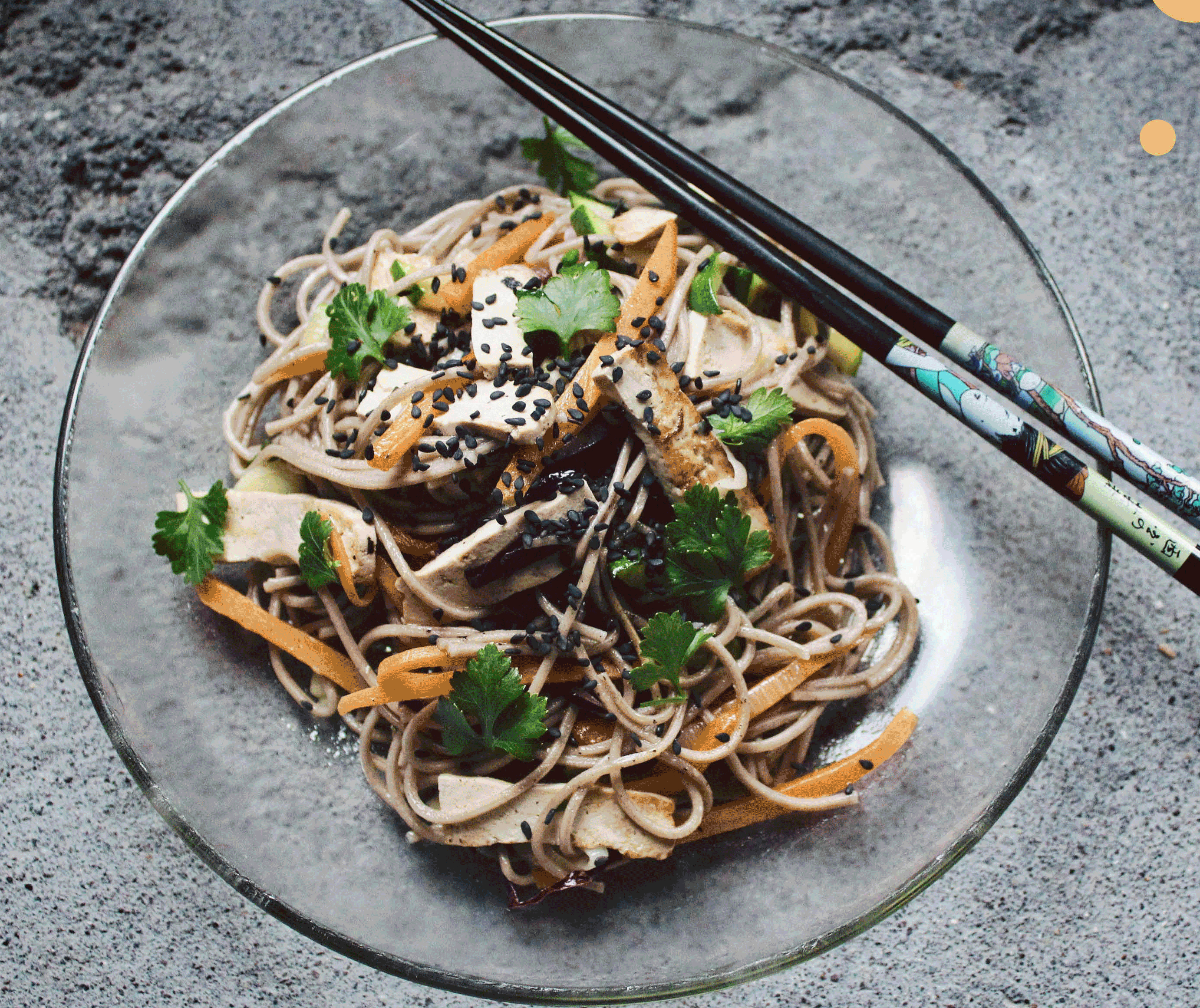 KI generiert: Ein Teller mit asiatischen Nudeln, Gemüse, Tofu und Sesam, mit Essstäbchen.