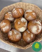 KI generiert: Ein Korb mit frischen, bemehlten Brötchen. Unten rechts ein Baum-Icon.