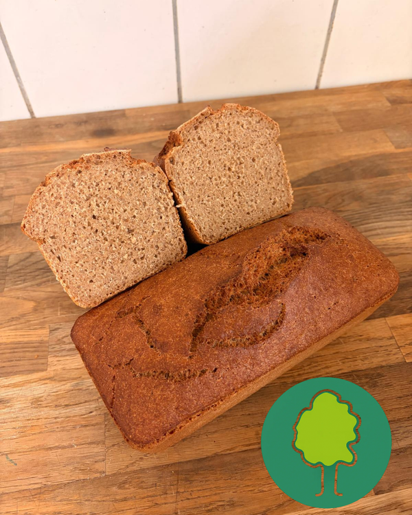 KI generiert: Ein Laib Brot mit zwei Scheiben dazu, auf einem Holztisch. Unten rechts ist ein Baum-Icon.
