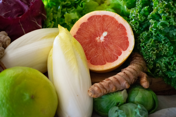 KI generiert: Das Bild zeigt eine Vielzahl von frischem Gemüse und Obst in einer grünen Kiste. Es hat den Titel "Warenkunde" mit dem Untertext "Was steckt in meiner Ökokiste?"